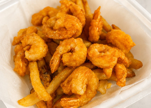 Ocean House fried shrimp and fries served in a takeout container